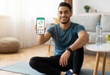 رجل رياضي يستخدم الهاتف لتصفح أفضل تطبيقات مجانية للياقة البدنية وحساب السعرات