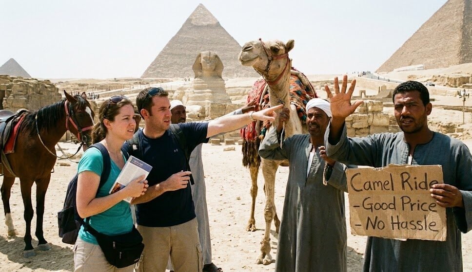 سائح يتفاوض بجدية مع صاحب جمل أمام أهرامات الجيزة للاتفاق على السعر قبل الركوب، صورة توضيحية لأهم نصائح تجنب الاستغلال السياحي في المناطق الأثرية