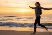 امرأة تمارس الجري على الشاطئ لتجربة فوائد الرياضة للصحة النفسية