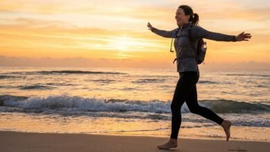 امرأة تمارس الجري على الشاطئ لتجربة فوائد الرياضة للصحة النفسية