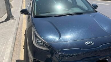 سيارة كيا نيرو كهربائية تُستخدم للعمل على تطبيقات النقل الذكي متوقفة في أحد شوارع عمان، الأردن