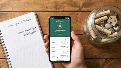 واجهة رقمية مستقبلية على شاشة زجاجية تعرض استراتيجية بناء صندوق طوارئ لعام 2026، تظهر رسوم بيانية تفاعلية لنمو المدخرات وخطط الأمان المالي السريع في بيئة مكتبية احترافية.